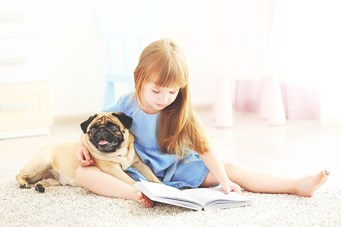 Girl with a pug on carpet