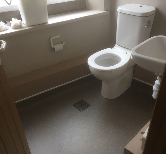 One of the toilets with the vinyl safety flooring.