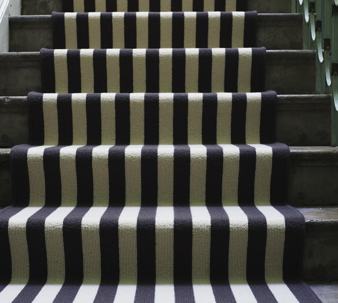 A striped runner on a wooden staircase