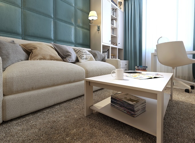 A small living room with a cream carpet.