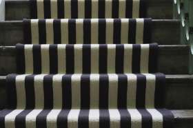 A striped runner on a wooden staircase